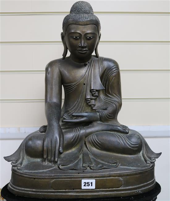 A 19th century Burmese bronze Buddha inset ebony and ivory eyes seated on bespoke lotus-carved polished wood column